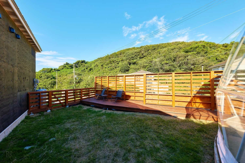 芝生が広がる庭とウッドデッキがある屋外空間