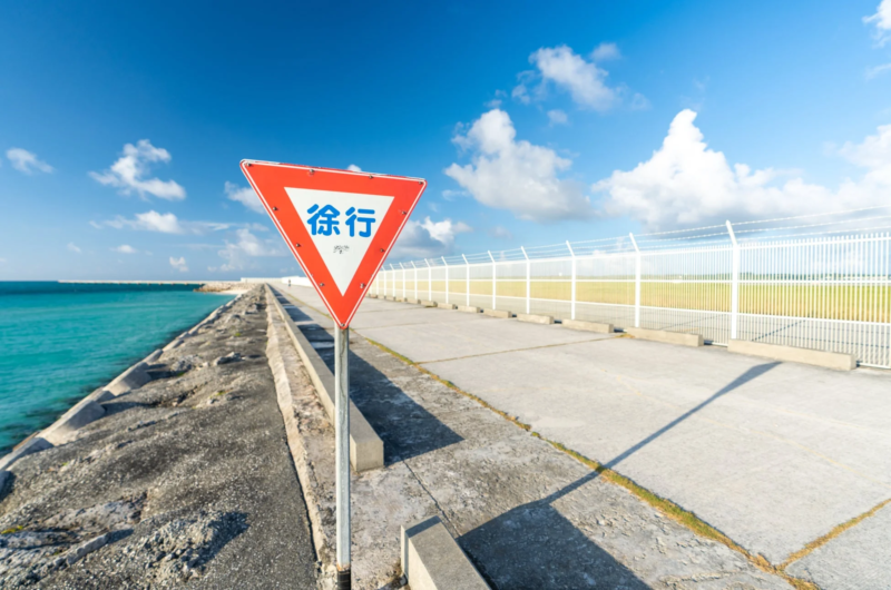 海岸沿いの道路と「徐行」標識