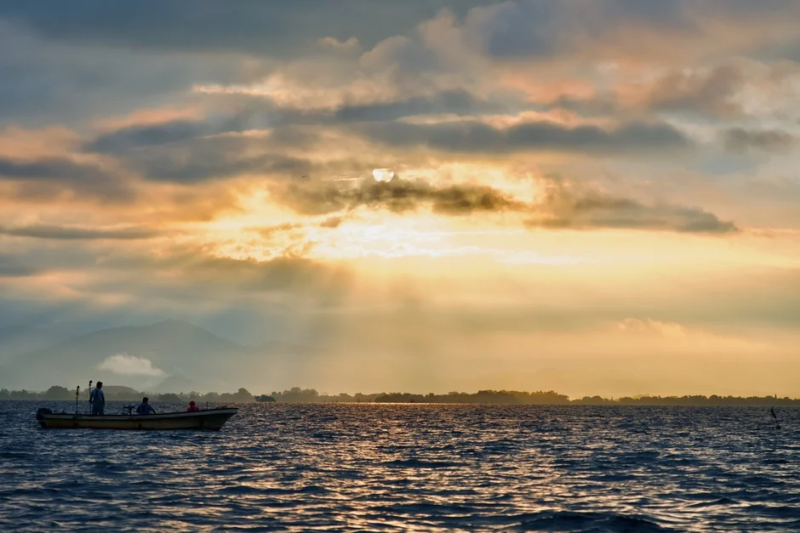 穏やかな湖面に浮かぶボートと夕焼け