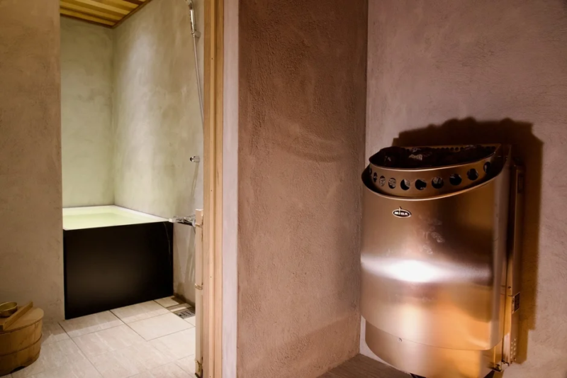 モダンな浴室に設置されたサウナヒーターと浴槽