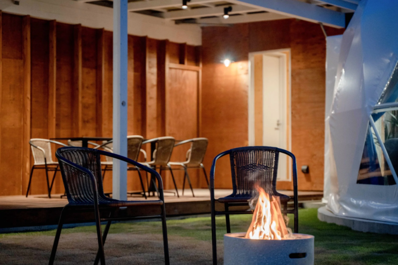 夜の屋外で燃え盛る焚き火とドームテント