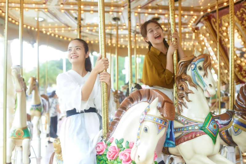 メリーゴーランドに乗って楽しむ2人の若い女性