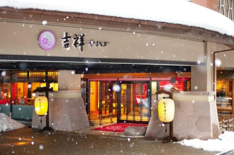 雪が降る旅館の入り口