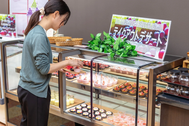 テイクアウトデザートを選ぶ女性