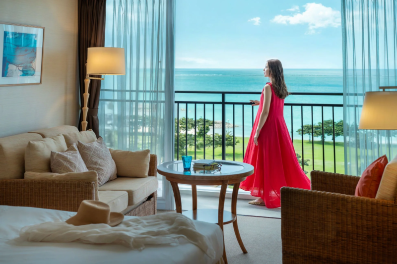 ホテルのバルコニーから海を眺める女性