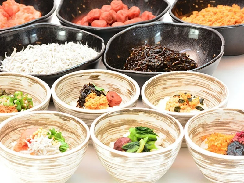 様々な種類の和食のおかずやご飯のお供が、複数の小鉢や器に盛り付けられています。