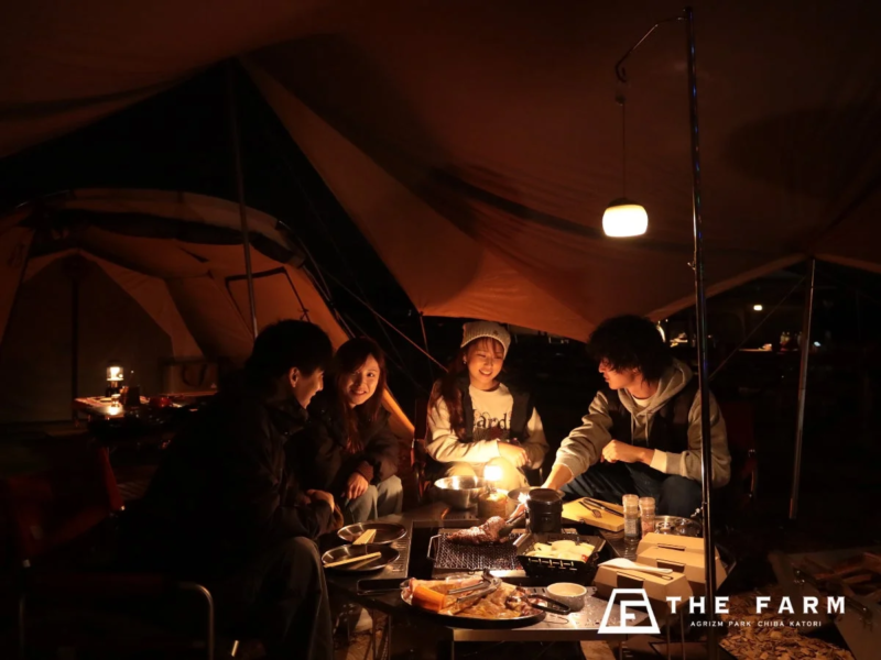 キャンプ場で焚き火を囲む人々