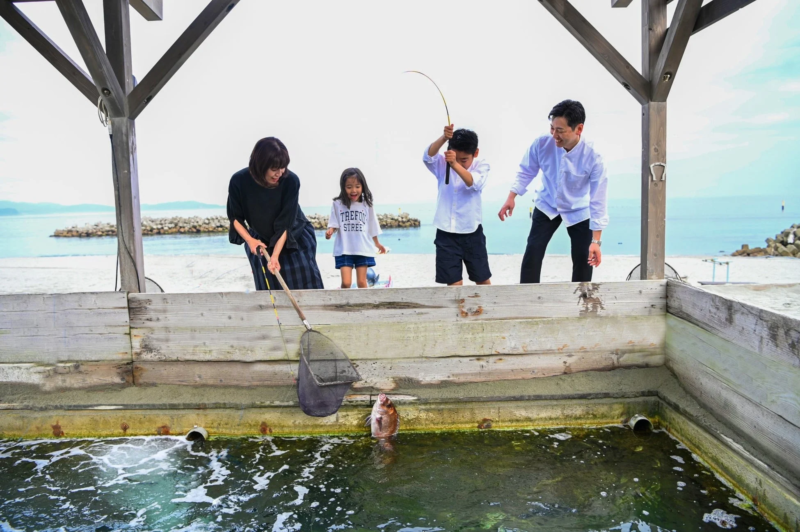 海辺の施設で家族が釣りを楽しんでいます。