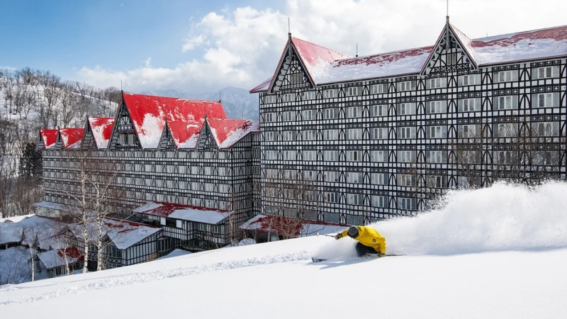 スキーヤーが滑走するホテルを背景にした冬景色