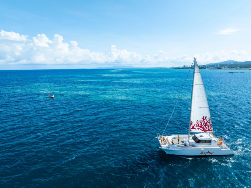 エメラルドグリーンの海を航行するヨット