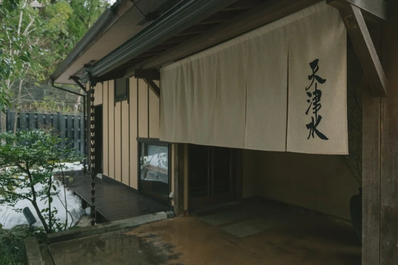 雪が積もる庭に面した和風建築の入り口