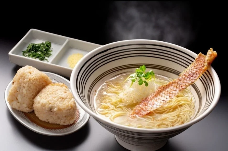 湯気が立つラーメンと、香ばしく揚げられた魚の皮が特徴的なセット。
