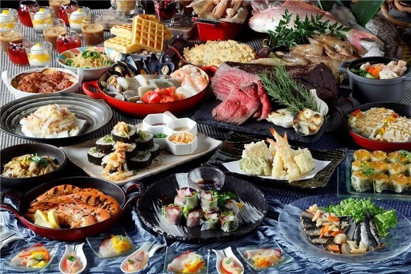 ローストビーフ、寿司、天ぷら、シーフード、パスタ、デザートなど、多種多様な豪華料理が並ぶビュッフェの様子