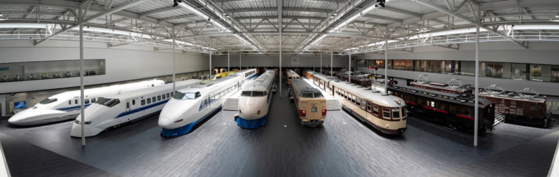 広々とした屋内展示場で、新幹線から旧型車両まで様々な種類の鉄道車両が展示されている鉄道博物館の様子