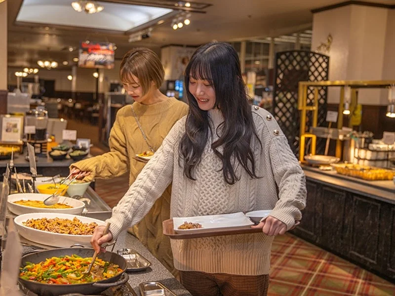 ビュッフェで料理を選ぶ女性2人