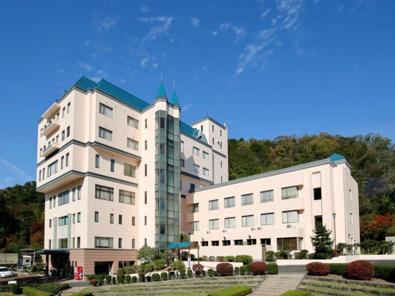 青い屋根とガラスのエレベーターが特徴的なホテルの外観