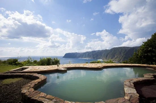 石造りのプールから広大な海と連なる山々を望む、開放感あふれる絶景