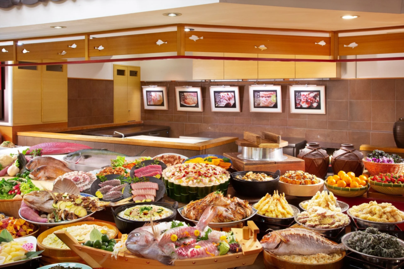 豪華な和食ビュッフェの様子。新鮮な魚介類を使った刺身や姿造り、天ぷらなど、種類豊富な料理が所狭しと並べられています