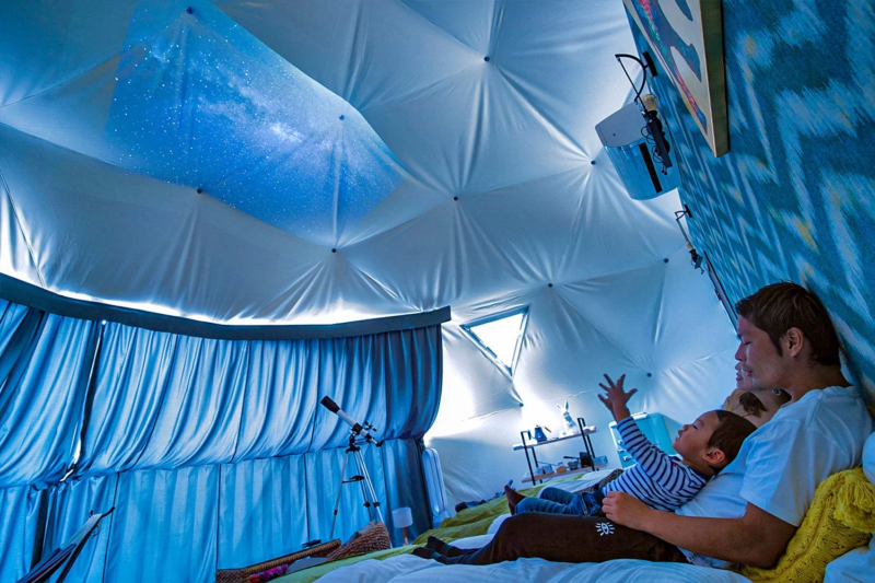 ドームテント内で星空を眺める親子