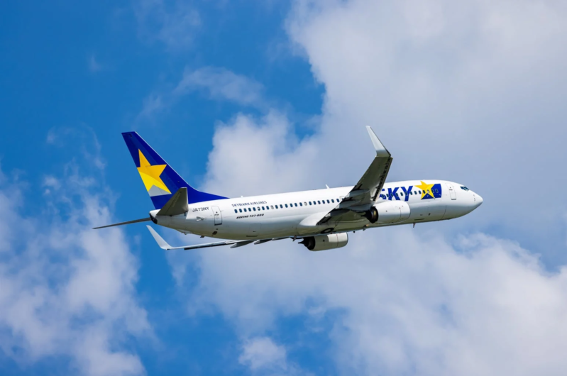 青空と白い雲の中を飛行するスカイマーク航空のボーイング737-800型機