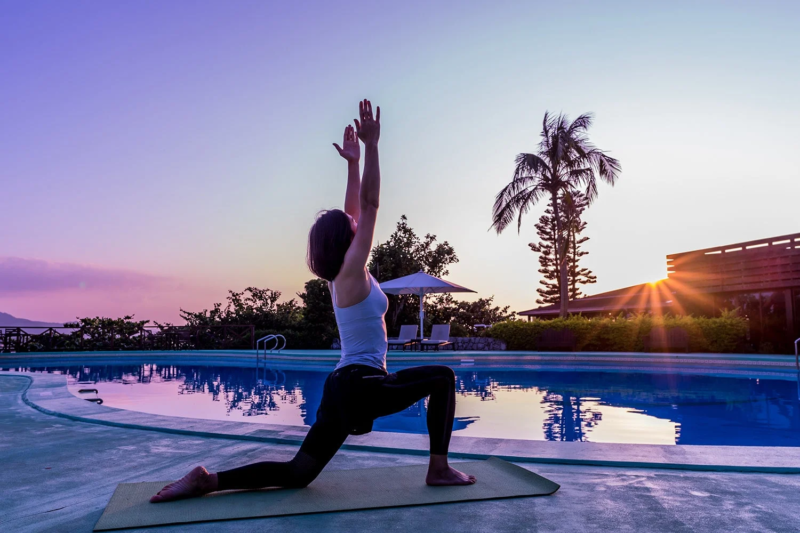 プールサイドでヨガをする女性