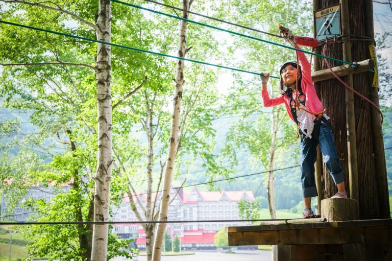 森で綱渡りを楽しむ少女