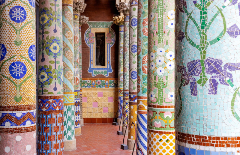 カラフルなモザイクタイルで装飾された柱が並ぶ、美しい回廊の風景