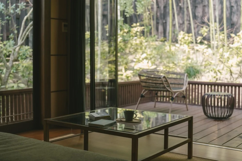 室内から広がるウッドデッキと緑豊かな庭園を望む穏やかな風景