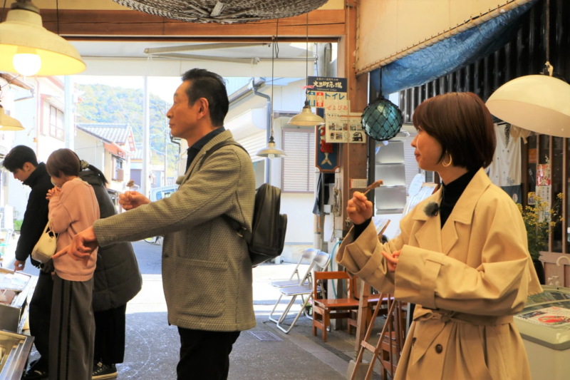 市場で串焼きを手に取る人々