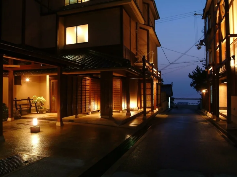 夕暮れ時、温かい光に照らされた日本の伝統的な建物が並ぶ路地