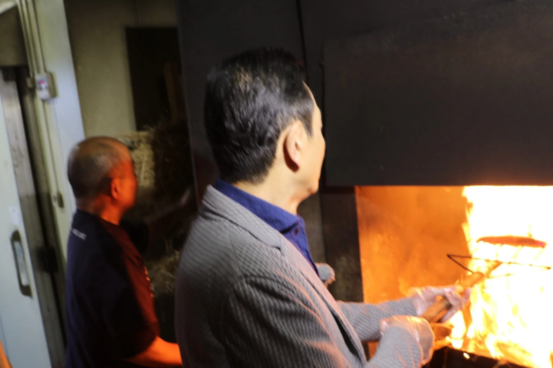 男性が炎を使ってカツオを藁焼きする様子