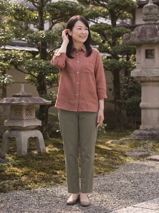 日本庭園で微笑む中年のアジア人女性