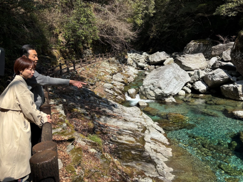 仁淀ブルーの渓谷を眺める男女