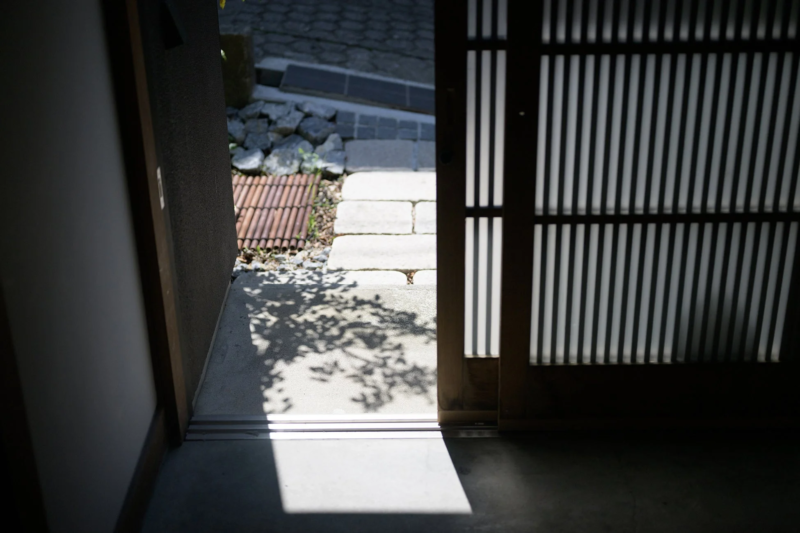日本家屋の引き戸から外の庭を覗く風景