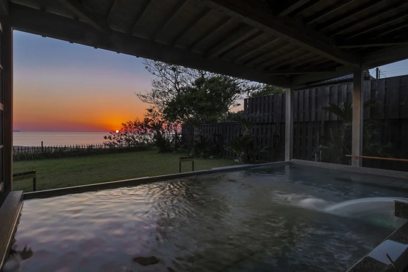 夕焼けが美しい海辺の露天風呂の風景