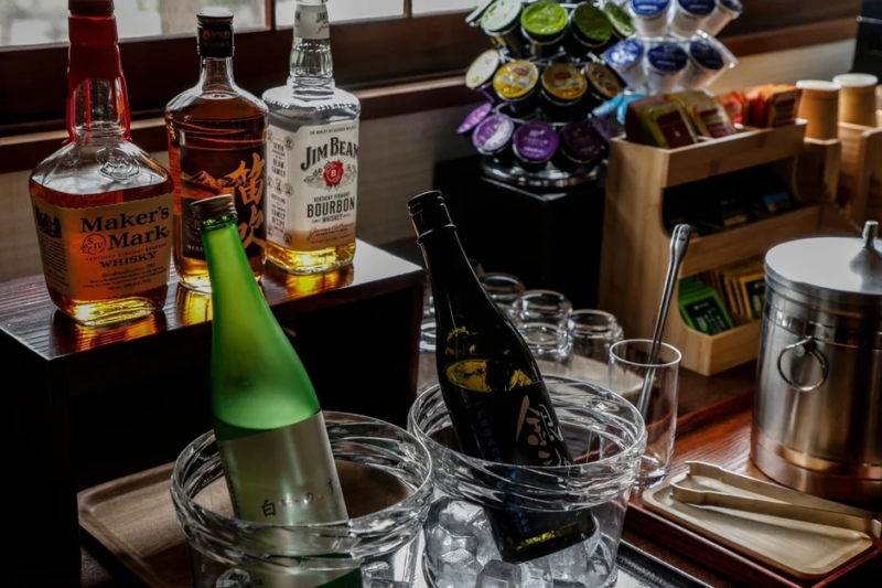 メーカーズマークやジムビームなどのウイスキー、日本酒が氷とグラスと共に用意されたドリンクコーナー