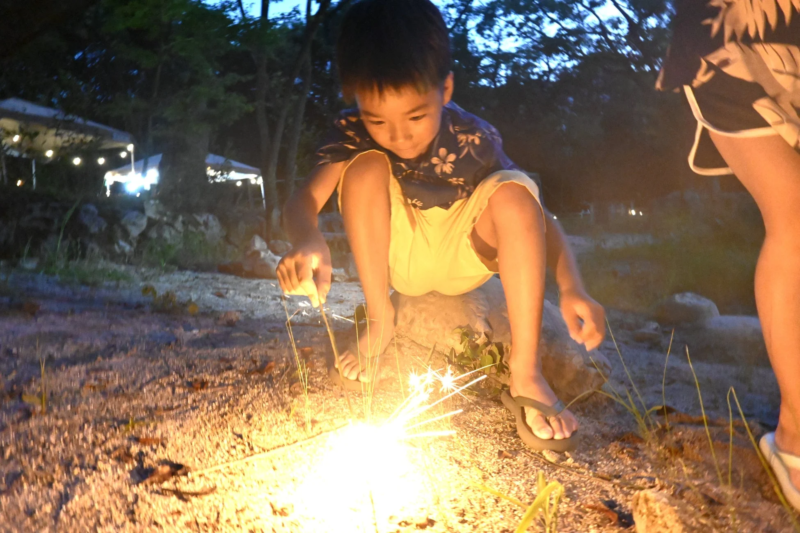 夏の夜、子供が線香花火を楽しんでいる様子