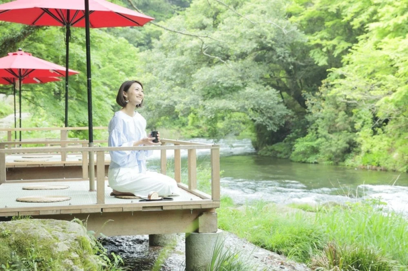 川沿いのテラス席の女性