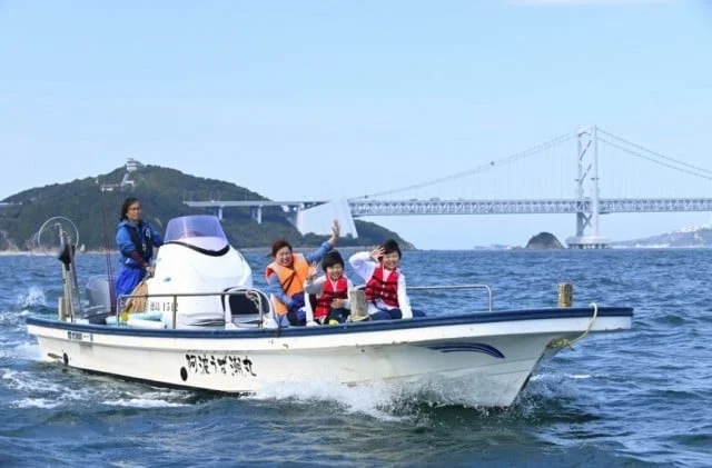 ボートに乗って海を楽しむ家族連れ
