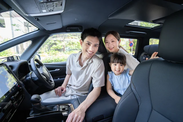 車内で楽しそうに笑顔を見せる家族の写真