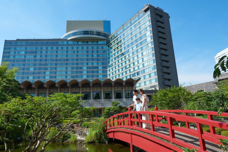 晴れた日に、モダンなホテルを背景に広がる日本庭園の風景