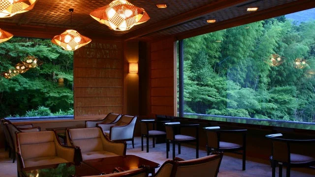 広々とした窓から豊かな緑の森林が広がる、落ち着いた雰囲気のラウンジです。